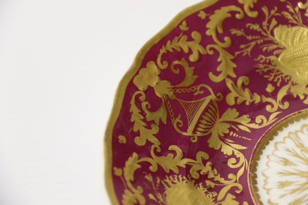 An early nineteenth-century Regency Spode porcelain cabinet cup and saucer featuring deep crimson ground decorated with heavy gilded scrollwork and shell motifs. View IX