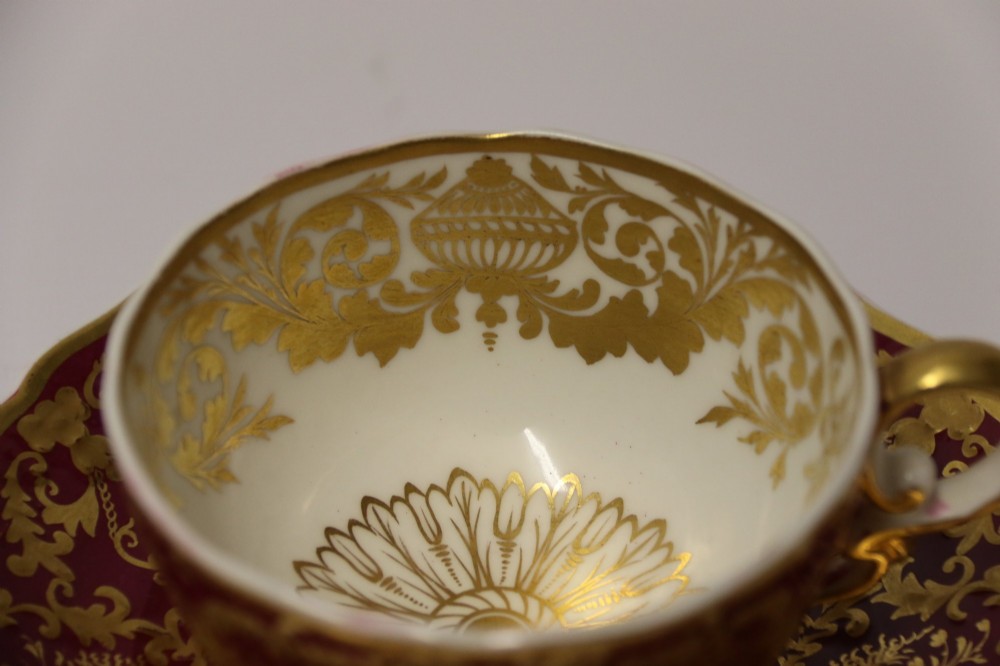 An early nineteenth-century Regency Spode porcelain cabinet cup and saucer featuring deep crimson ground decorated with heavy gilded scrollwork and shell motifs. View XI