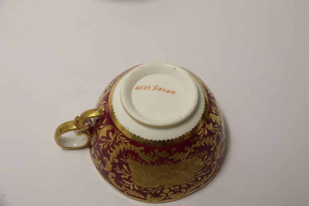An early nineteenth-century Regency Spode porcelain cabinet cup and saucer featuring deep crimson ground decorated with heavy gilded scrollwork and shell motifs. View XIII