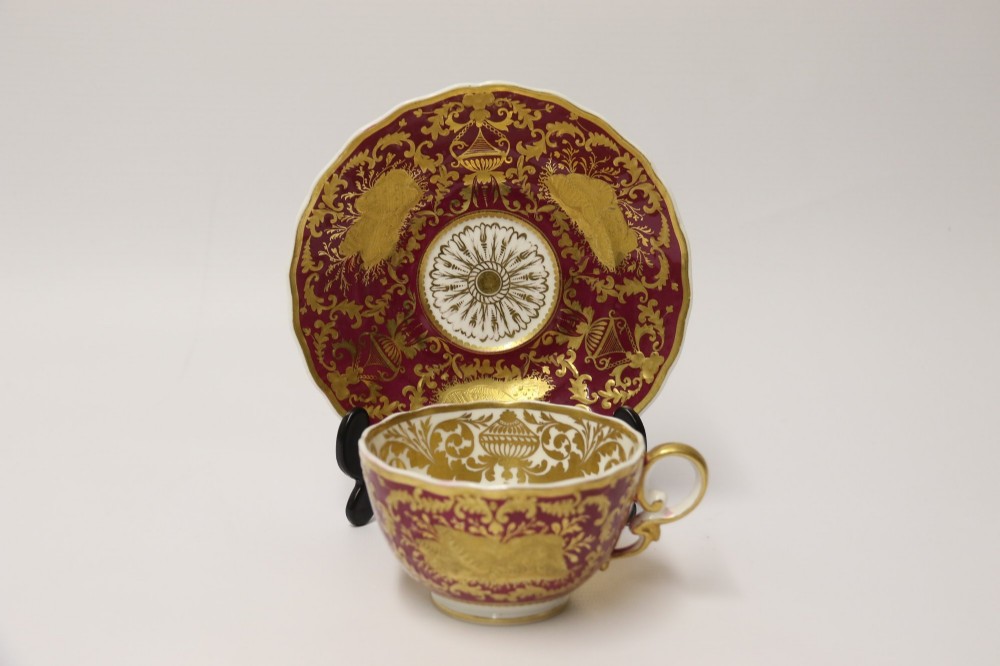 An early nineteenth-century Regency Spode porcelain cabinet cup and saucer featuring deep crimson ground decorated with heavy gilded scrollwork and shell motifs. View XV