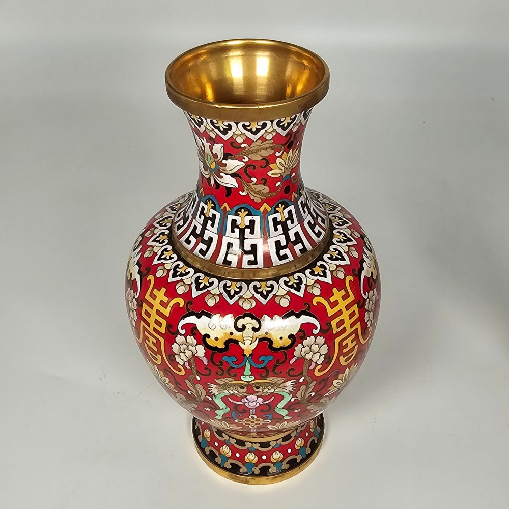 A matching pair of baluster-form Chinese cloisonne enamel vases with red backgrounds, lotus motifs, auspicious symbols, and gilt rims. View II