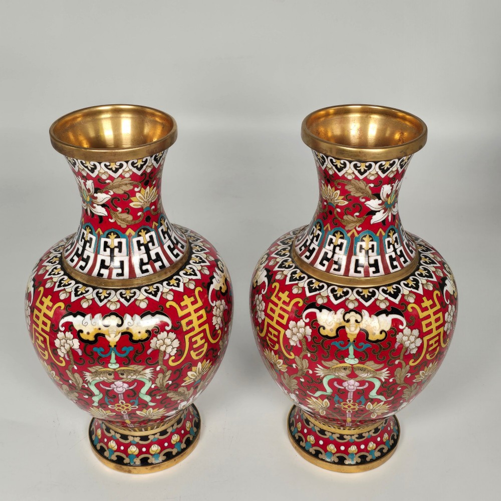 A matching pair of baluster-form Chinese cloisonne enamel vases with red backgrounds, lotus motifs, auspicious symbols, and gilt rims. View III