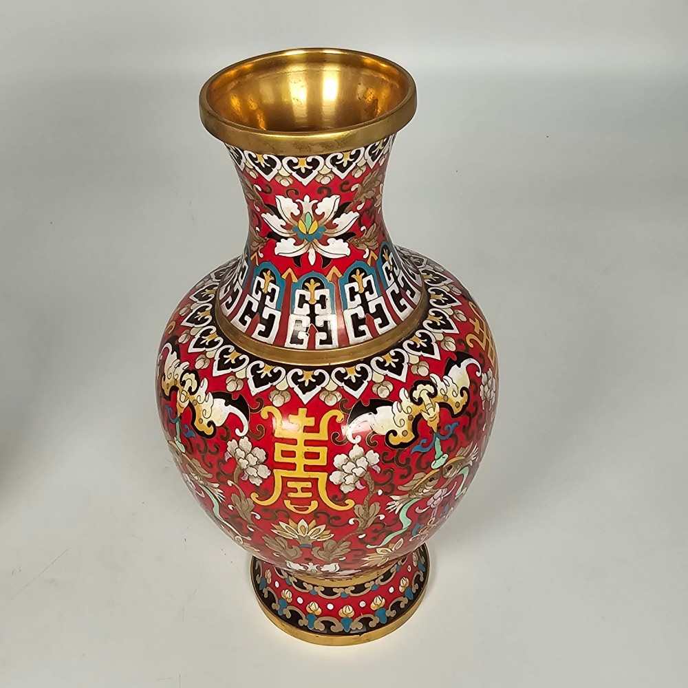 A matching pair of baluster-form Chinese cloisonne enamel vases with red backgrounds, lotus motifs, auspicious symbols, and gilt rims. View IV