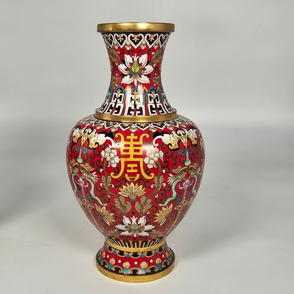 A matching pair of baluster-form Chinese cloisonne enamel vases with red backgrounds, lotus motifs, auspicious symbols, and gilt rims. View VIII
