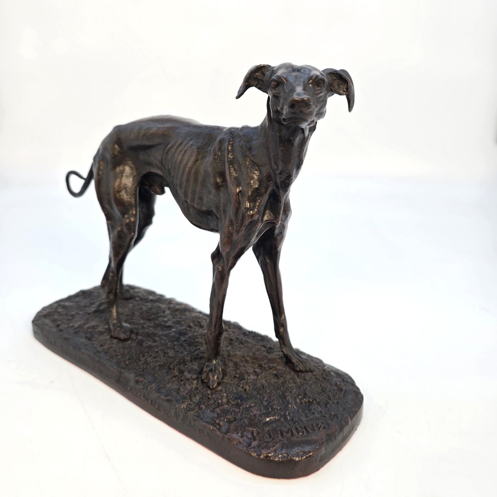 A 19th-century dark patinated bronze sculpture of a standing greyhound dog on a textured oval base. View III