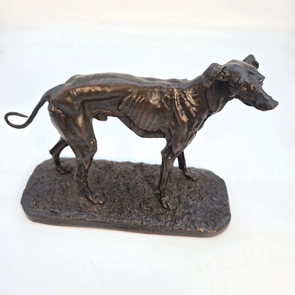 A 19th-century dark patinated bronze sculpture of a standing greyhound dog on a textured oval base. View VI