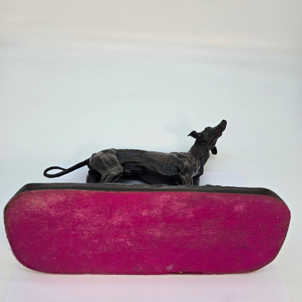 A 19th-century dark patinated bronze sculpture of a standing greyhound dog on a textured oval base. View XIV
