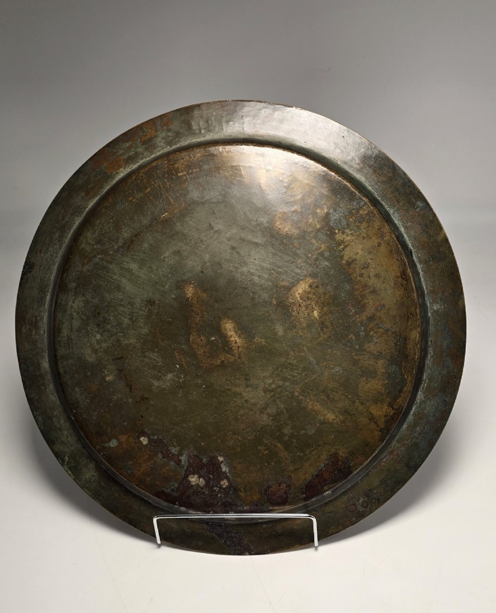 A circular bronze charger decorated with silver and copper inlays depicting pharaonic figures, hieroglyphs, and a winged sun deity. View XIV