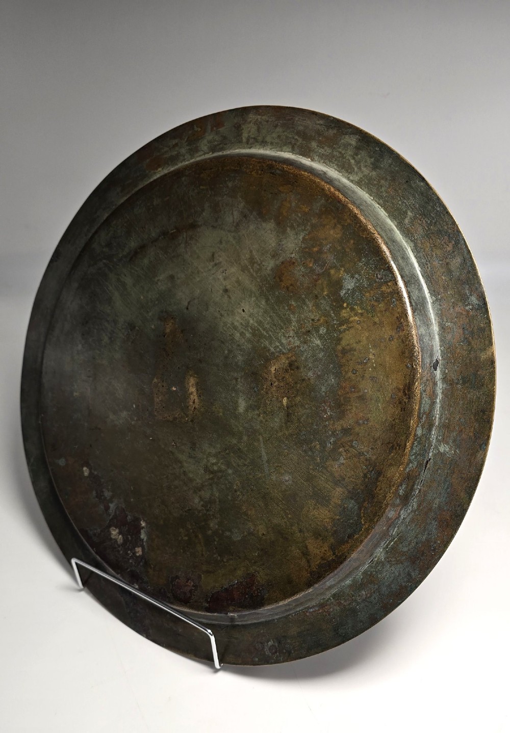 A circular bronze charger decorated with silver and copper inlays depicting pharaonic figures, hieroglyphs, and a winged sun deity. View XV