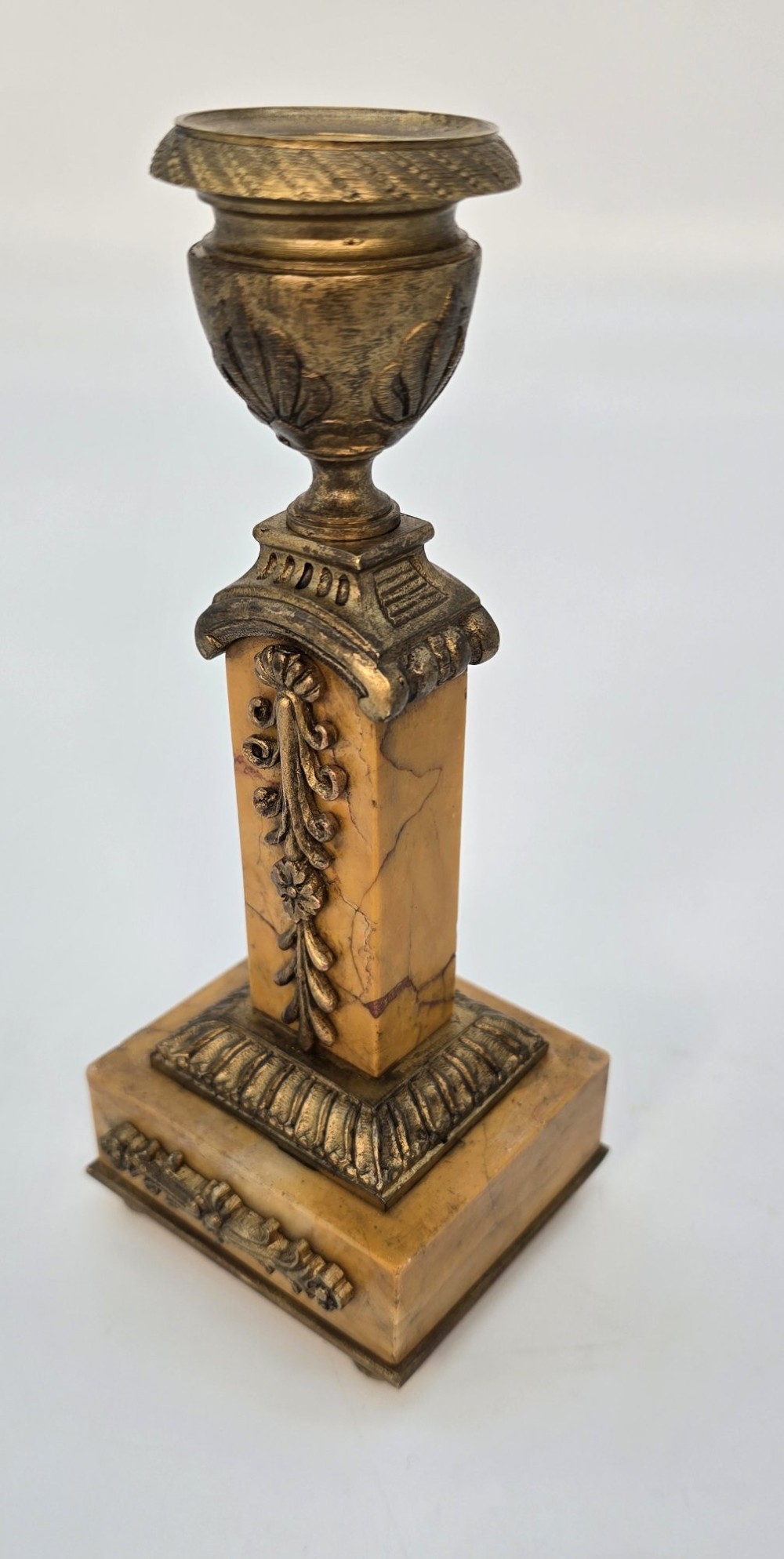 A pair of nineteenth-century French Empire gilt-bronze candlesticks featuring urn-shaped nozzles and applied bronze foliage on rectangular yellow marble bases. View III