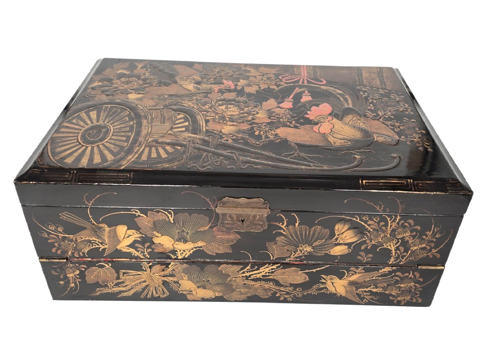 An open black lacquer writing box decorated with gold floral and bird motifs, revealing internal stationery compartments. View XII