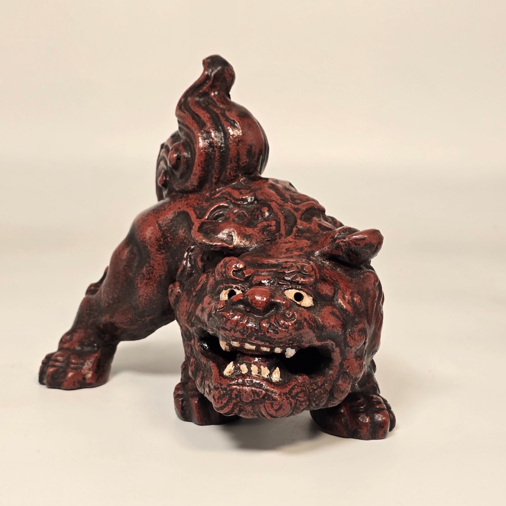 A pair of reddish-brown cast iron Chinoiserie guardian lions with swirling manes and open mouths displaying white painted teeth. View III
