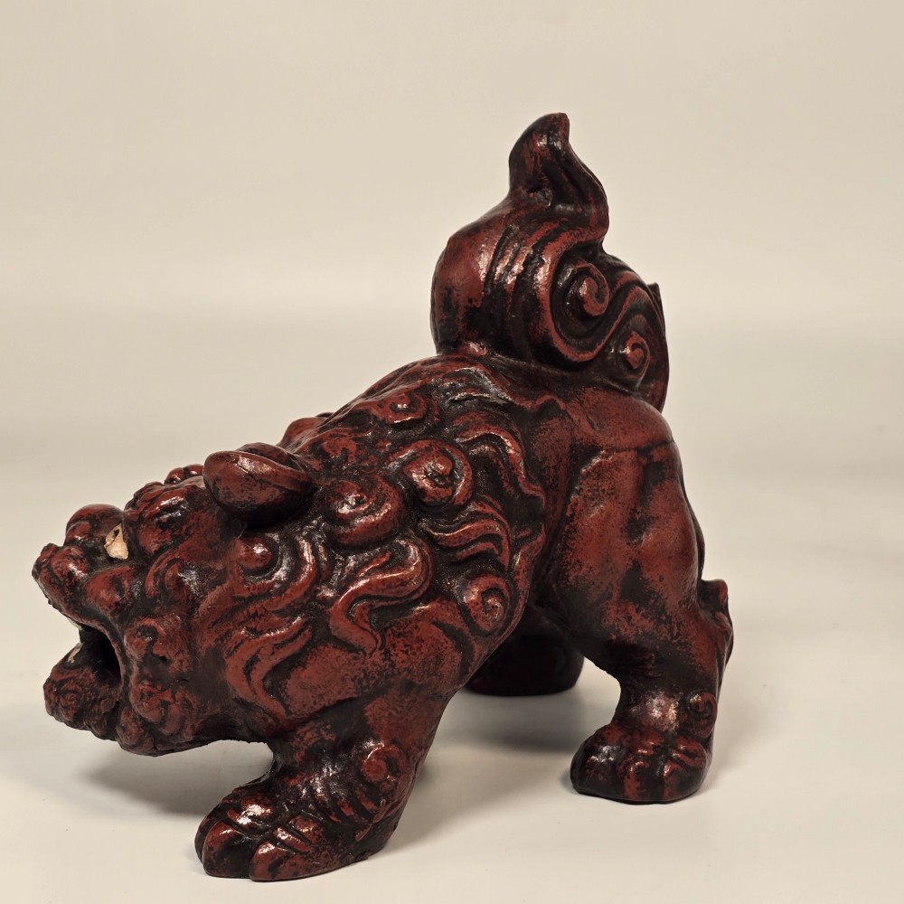 A pair of reddish-brown cast iron Chinoiserie guardian lions with swirling manes and open mouths displaying white painted teeth. View V