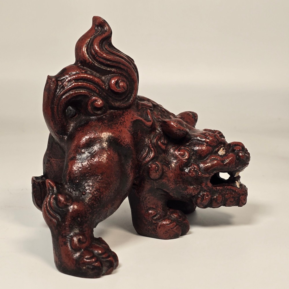 A pair of reddish-brown cast iron Chinoiserie guardian lions with swirling manes and open mouths displaying white painted teeth. View IX