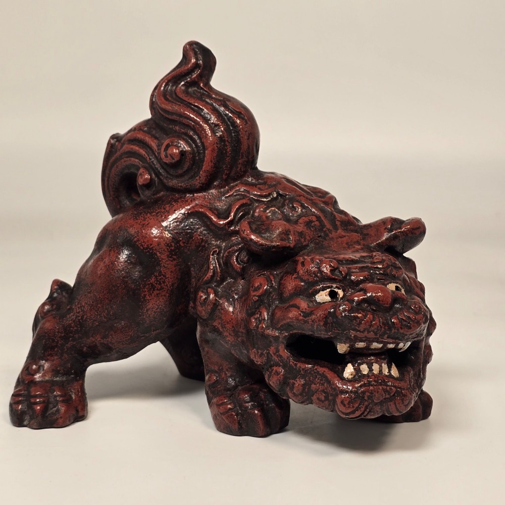 A pair of reddish-brown cast iron Chinoiserie guardian lions with swirling manes and open mouths displaying white painted teeth. View X