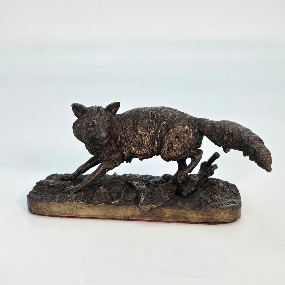 A dark brown patinated bronze sculpture depicting a crouching fox on a naturalistic textured base. View VII