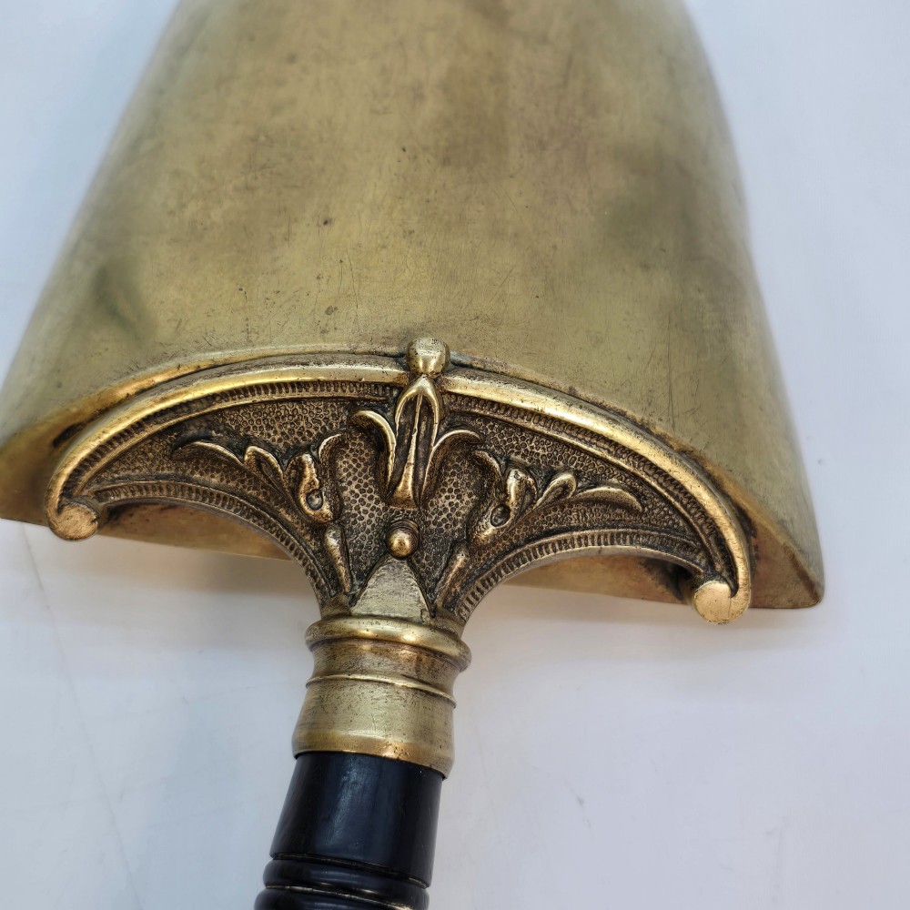 Victorian sloped brass coal box featuring repousse sunflower motifs, turned brass feet, and a top carrying handle with an integrated rear shovel. View VIII