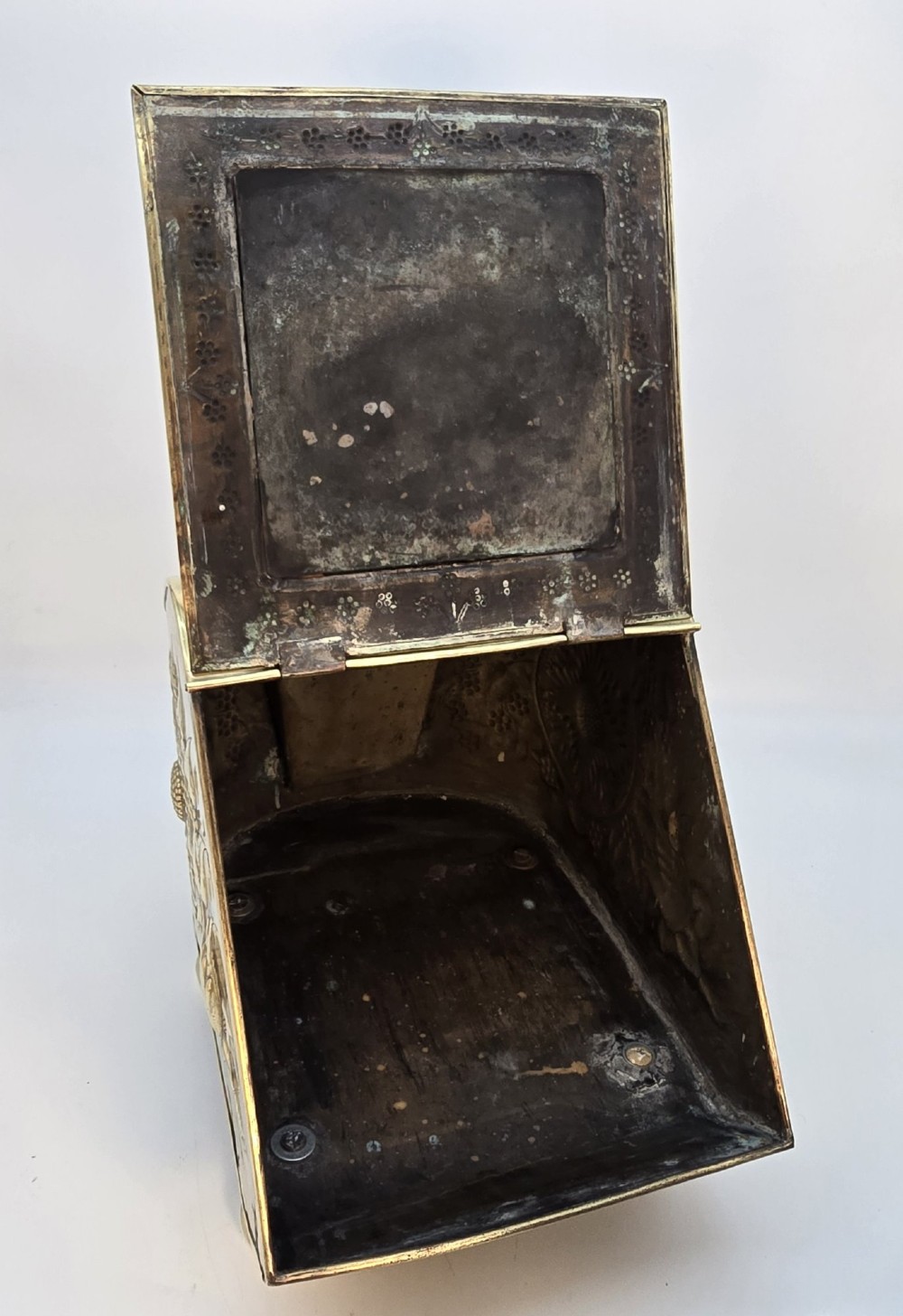Victorian sloped brass coal box featuring repousse sunflower motifs, turned brass feet, and a top carrying handle with an integrated rear shovel. View XII