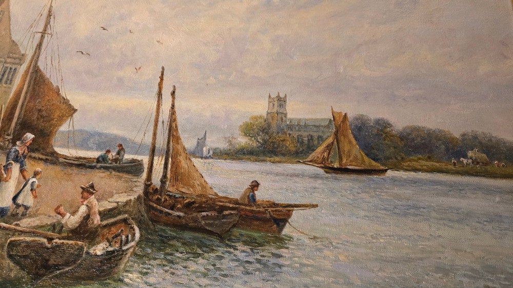 An antique oil painting depicting a coastal harbour scene with boats and figures, set within an ornate carved gold frame. View IV