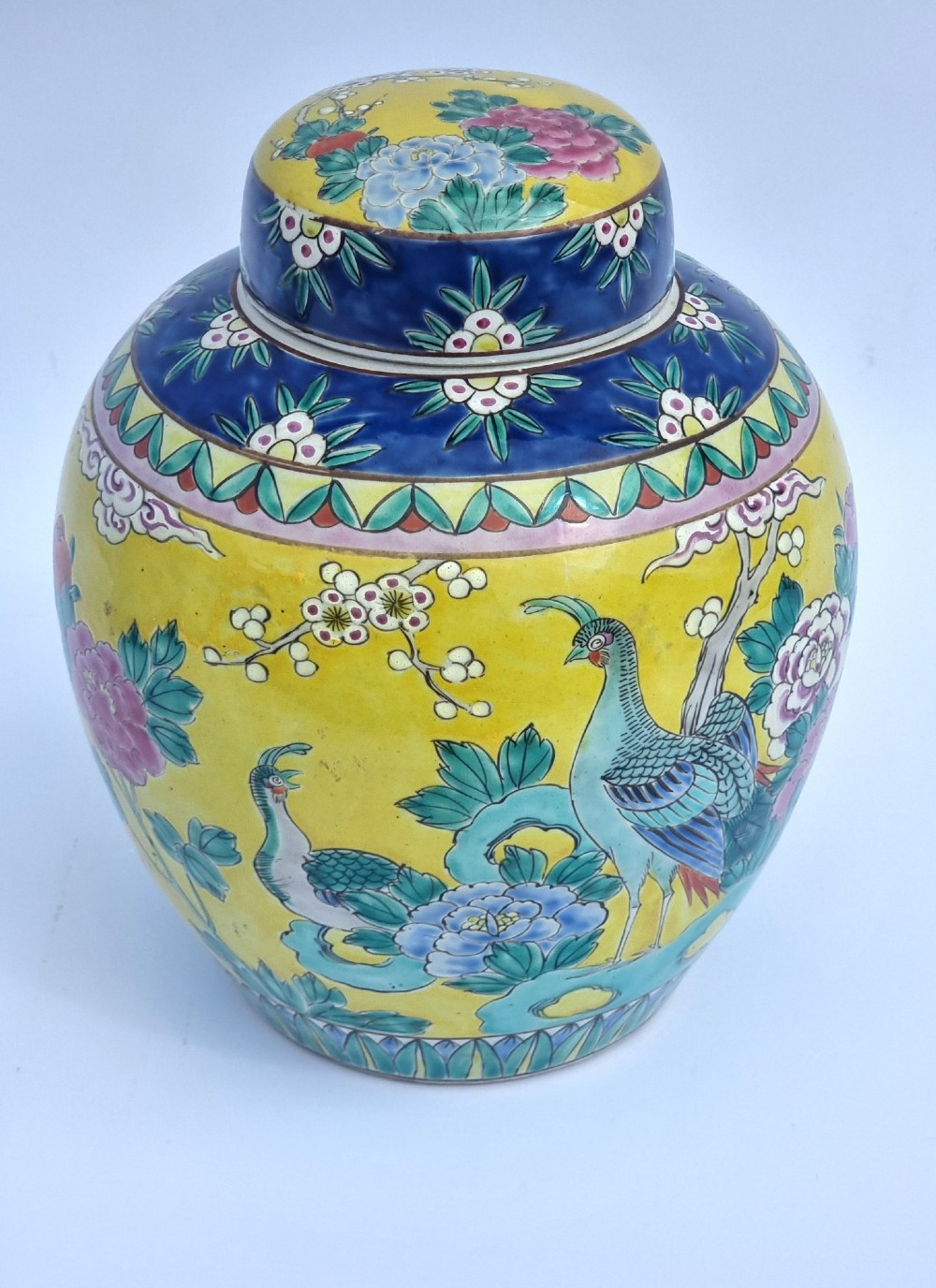 A pair of hand-painted Chinese porcelain ginger jars featuring yellow grounds decorated with pheasants and peonies, capped with blue patterned lids. View X