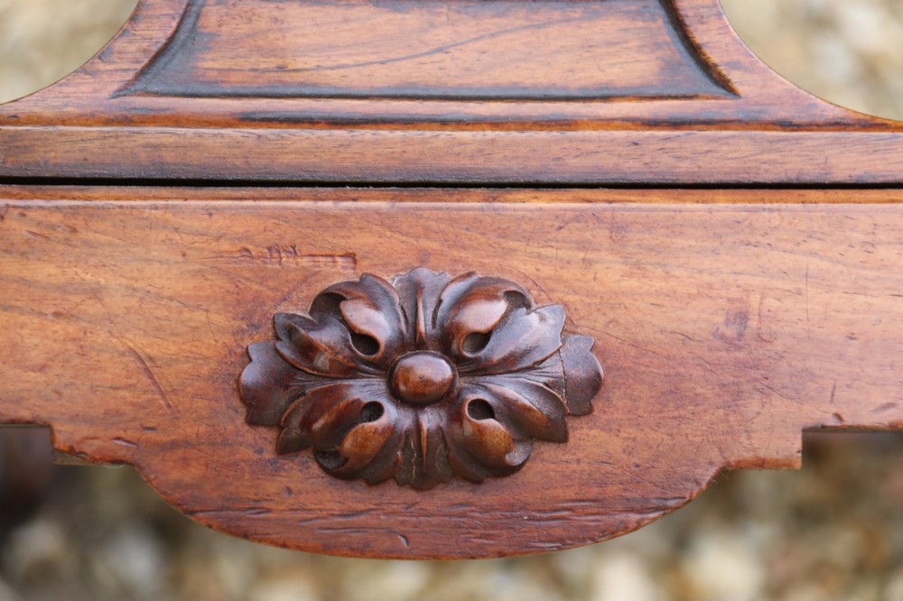 An early 19th-century flame mahogany library table featuring floral marquetry inlays around the rectangular top, frieze drawers with brass handles, and carved trestle supports. View IX