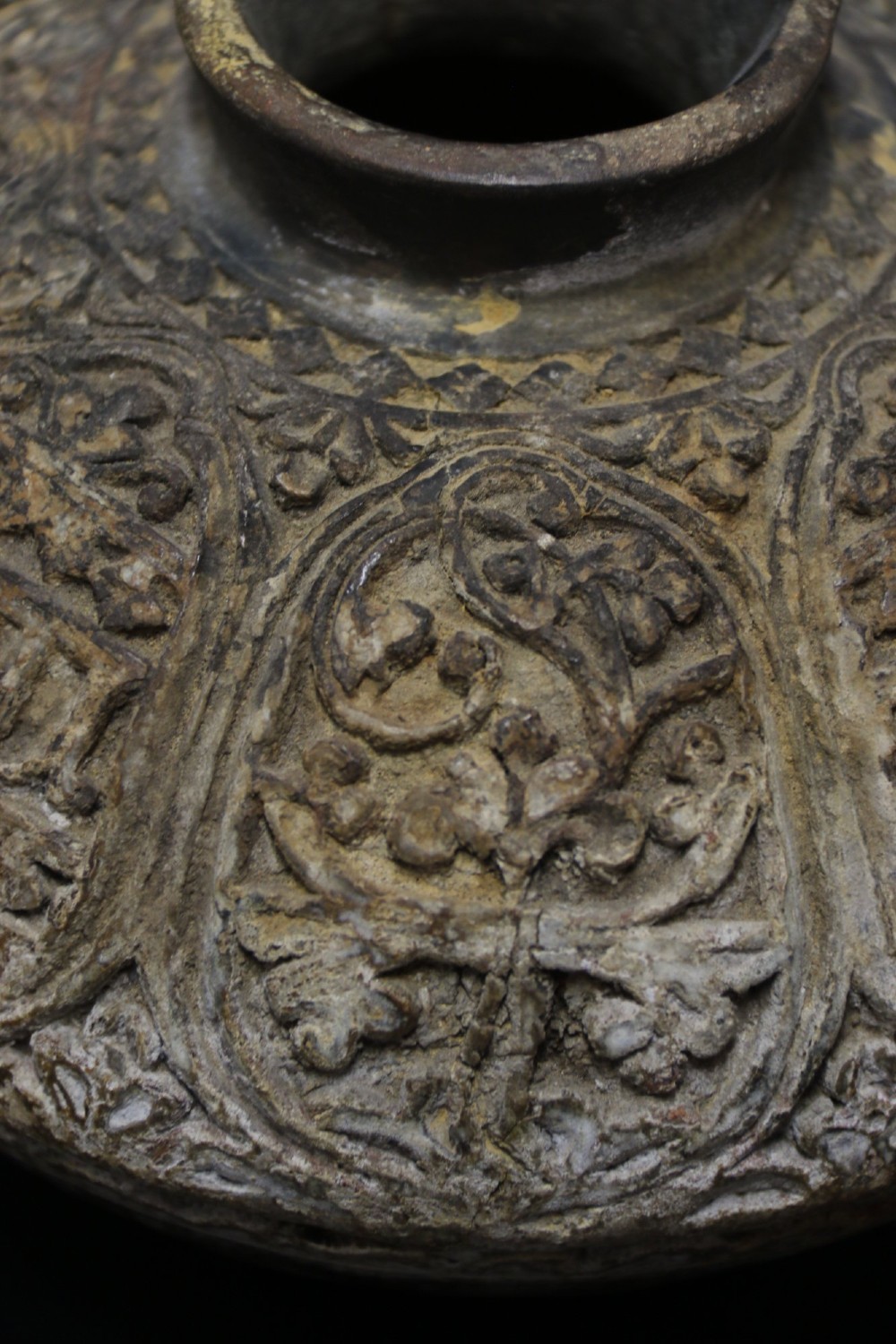 A squat rounded 17th-century Indian earthenware vase featuring deeply incised floral motifs and a low flared neck. View VI