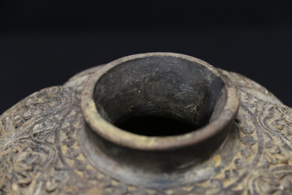 A squat rounded 17th-century Indian earthenware vase featuring deeply incised floral motifs and a low flared neck. View VIII