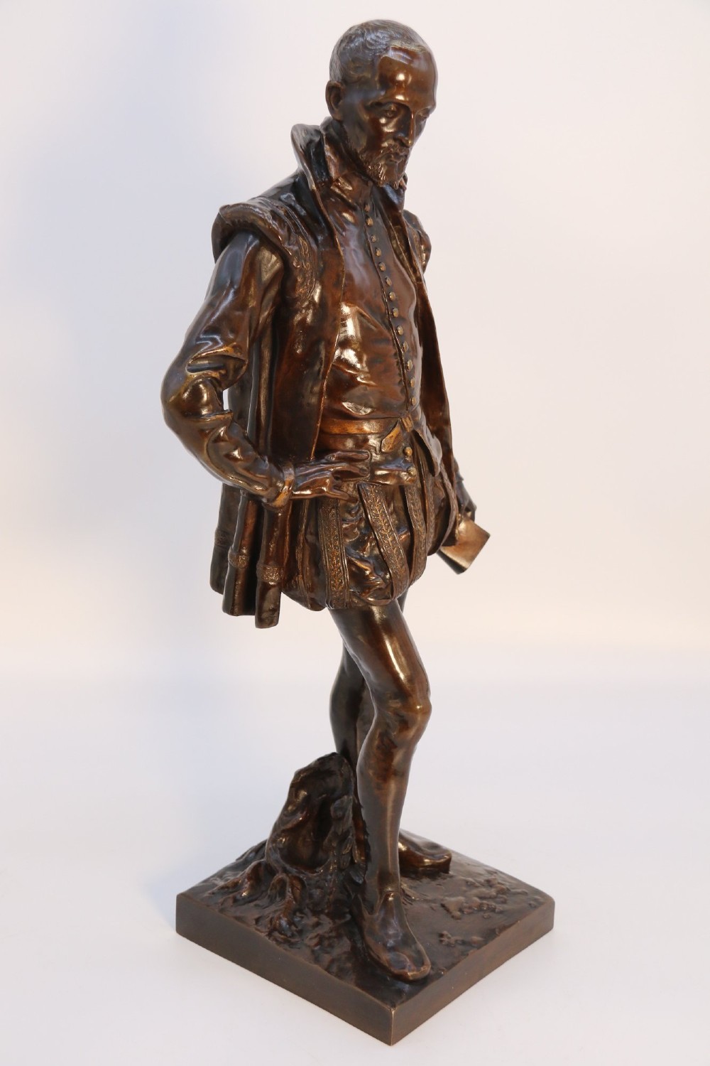 A 19th-century patinated bronze standing figure depicting a Renaissance poet in detailed attire, mounted on a rectangular bronze base. View X