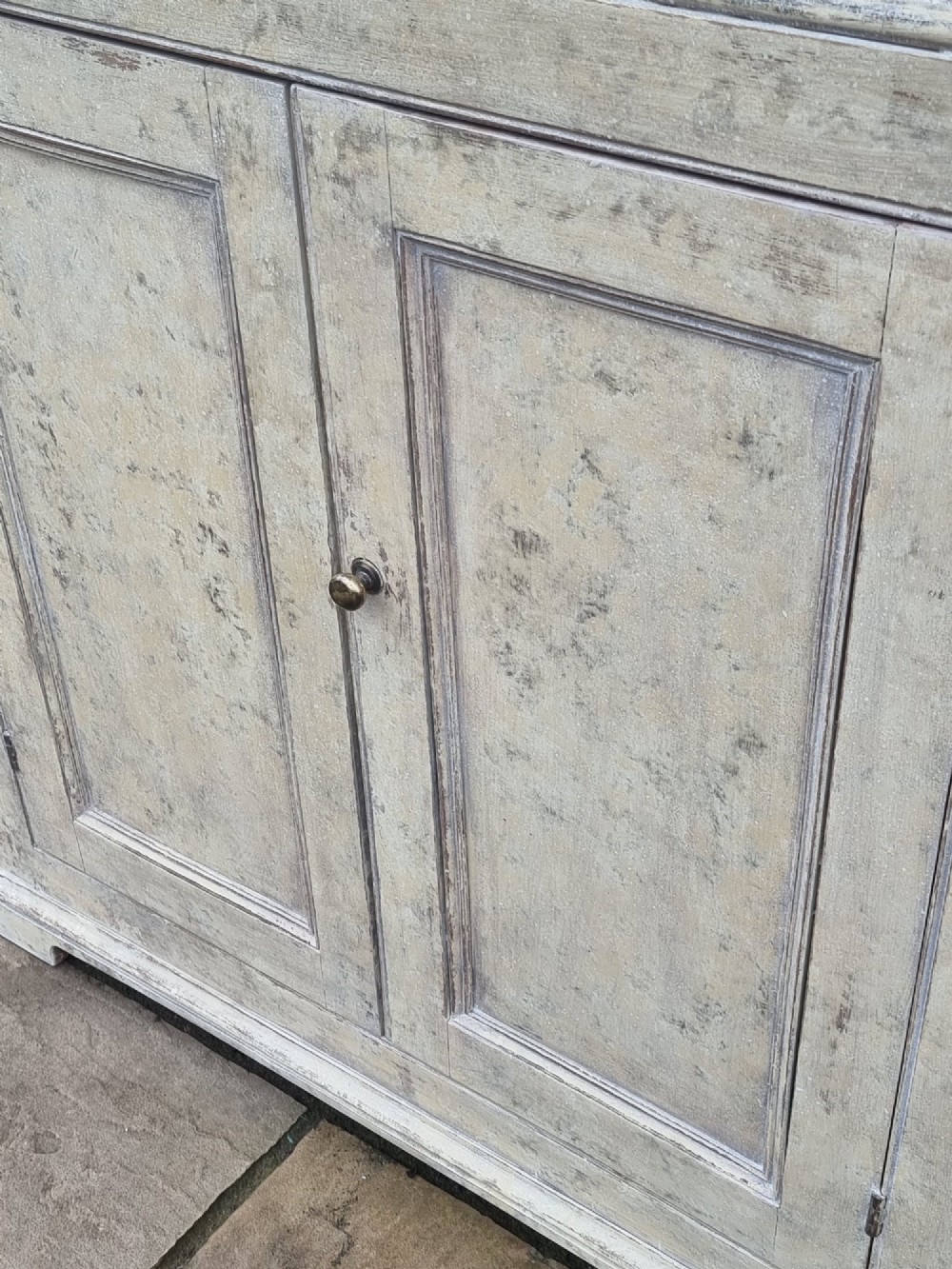 An antique two-part painted corner cupboard featuring an upper section with diamond-latticed glass doors showing a red painted interior and a solid two-door lower cabinet. View IV