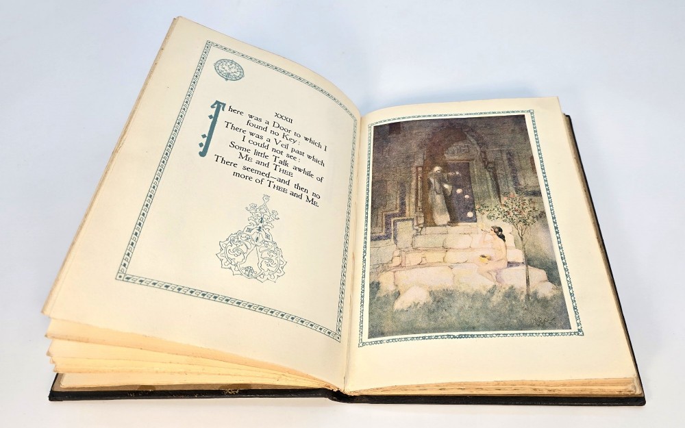 An early 20th-century dark leather-bound copy of the Rubaiyat of Omar Khayyam featuring gilt lettering and red illuminated strapwork detailing. View V
