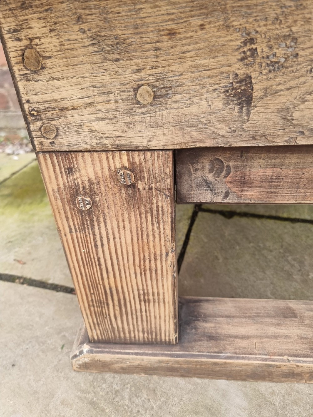 A low rectangular rustic oak table featuring a heavily distressed painted top with linear detailing supported by thick trestle legs. View VI