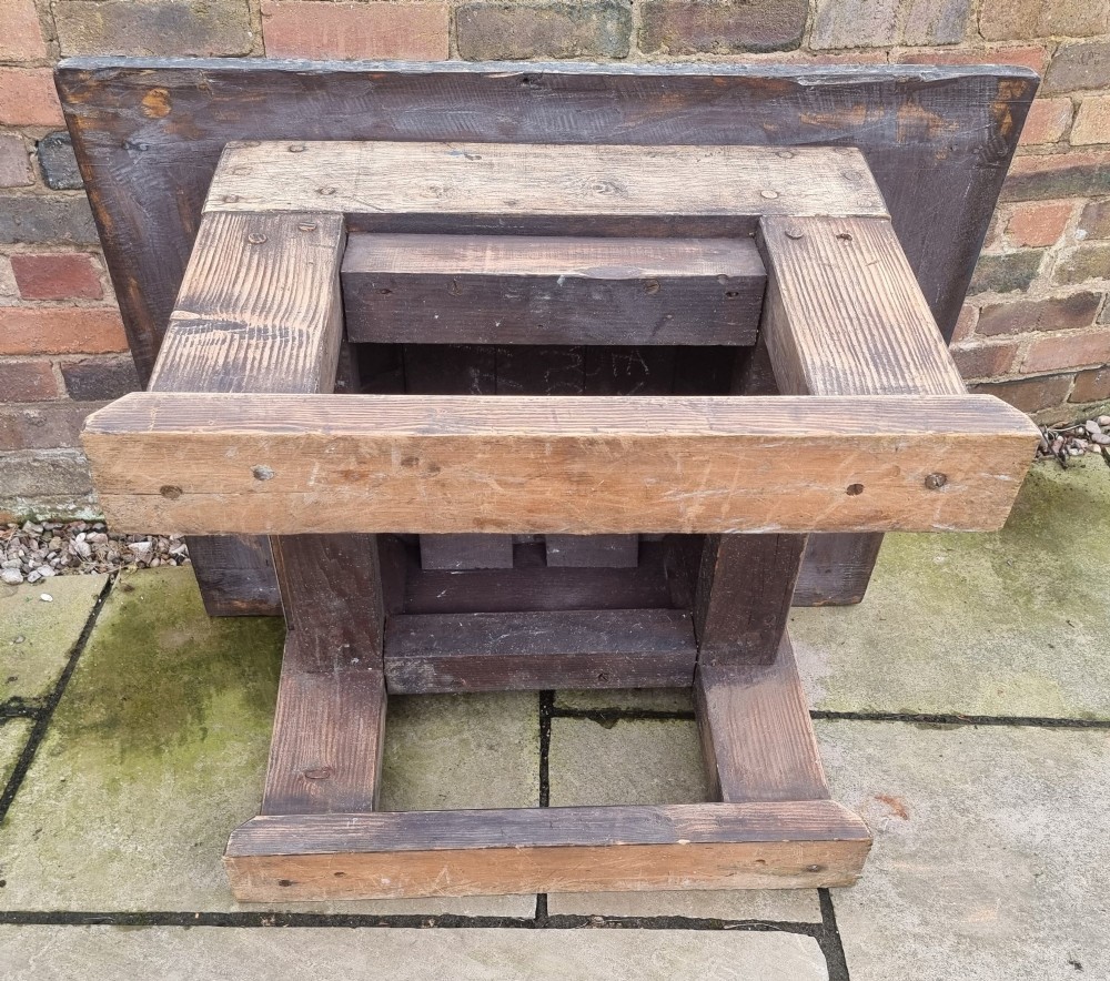 A low rectangular rustic oak table featuring a heavily distressed painted top with linear detailing supported by thick trestle legs. View VIII
