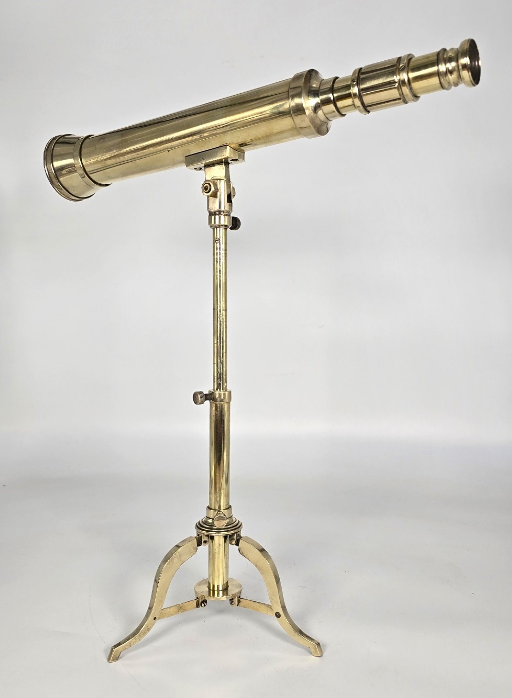 A Victorian brass tabletop telescope mounted on an adjustable folding brass tripod stand. View III