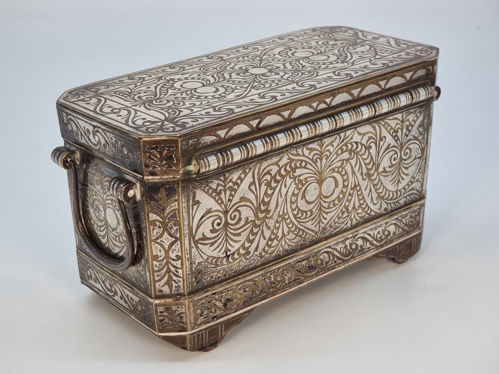 A rectangular dark bronze betel box embellished with detailed silver floral scrollwork inlay and featuring side handles. View III