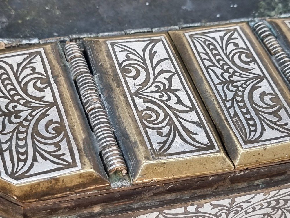 A rectangular dark bronze betel box embellished with detailed silver floral scrollwork inlay and featuring side handles. View X