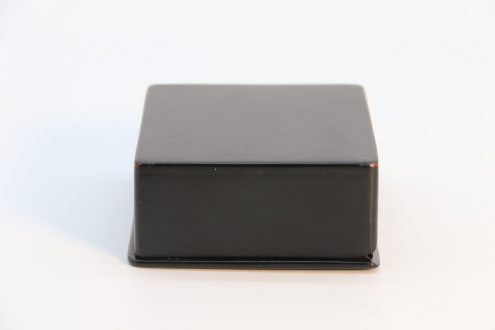 A rectangular black lacquered box featuring a hand-painted portrait of a young woman with a red ribbon in her hair on the top lid. View V