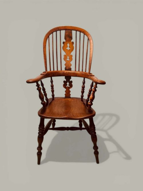 fig 1. A late nineteenth-century Windsor armchair crafted from ash and elm with a hoop back, decorative pierced splat, broad armrests, and turned legs.