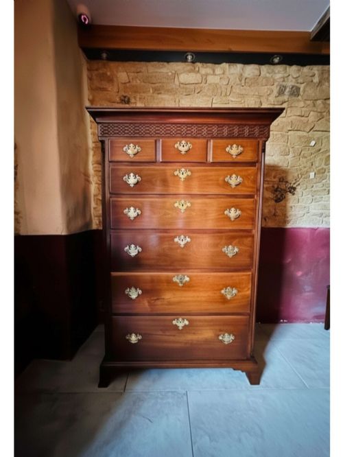 fig 1. A tall 19th-century walnut chest of drawers featuring a carved fretwork frieze, brass backplate handles, and graduated drawer fronts.