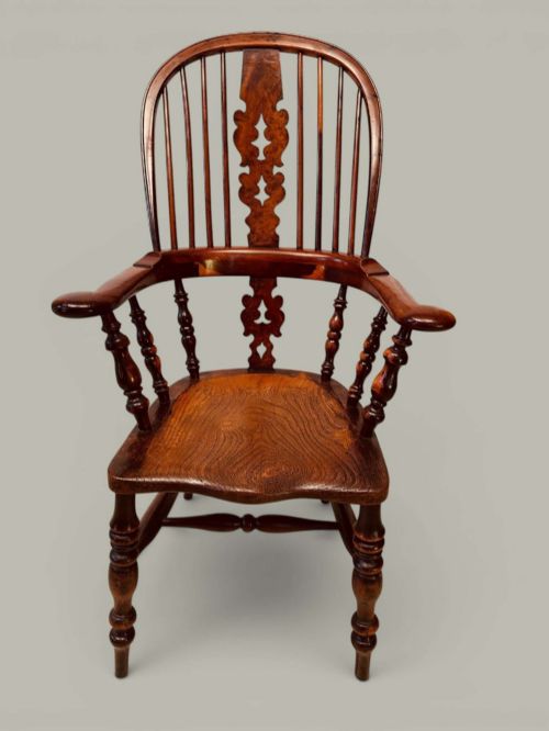 fig 1. A pair of 19th-century yew and elm Windsor armchairs featuring curved hoop backs, pierced central splats, broad armrests, and turned legs.