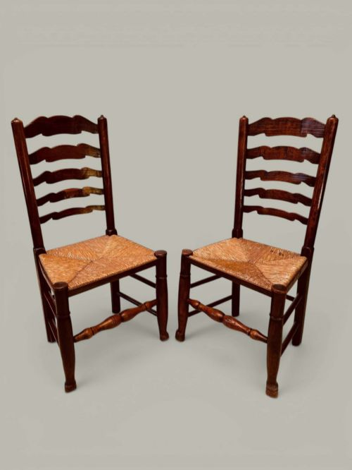 fig 2. A set of eight antique ash dining chairs featuring wavy ladder backs, turned stretchers, and woven rush seats, comprising six side chairs and two carver armchairs.