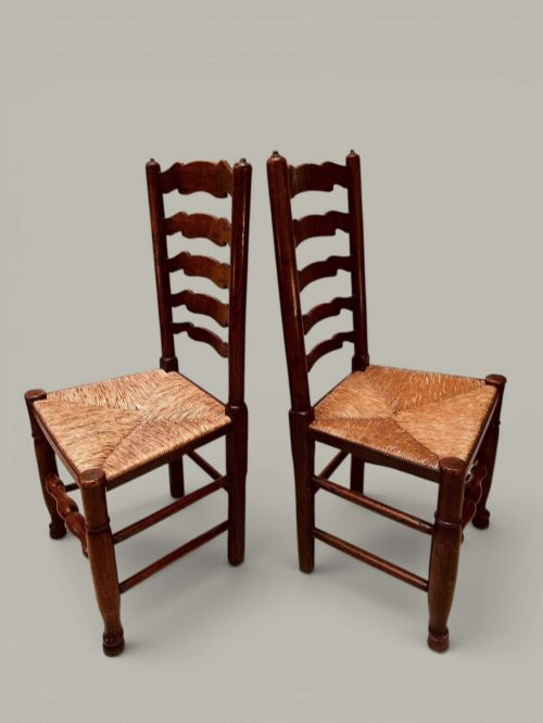 fig 3. A set of eight antique ash dining chairs featuring wavy ladder backs, turned stretchers, and woven rush seats, comprising six side chairs and two carver armchairs.