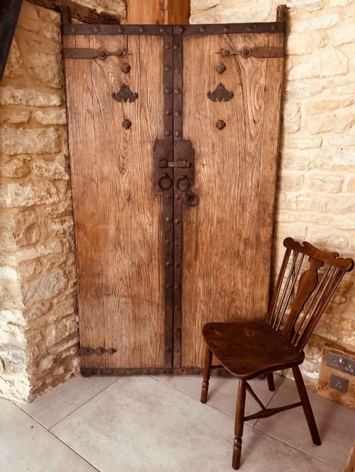 fig 1. A pair of antique Chinese reclaimed locust wood doors with iron straps, decorative studs, and central ring handles.