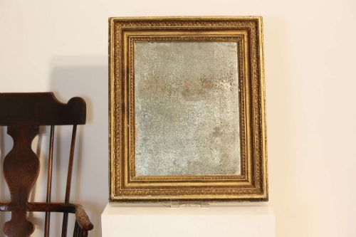 fig 1. A 19th-century French rectangular giltwood wall mirror featuring a moulded frame with detailed borders and a heavily foxed glass plate.
