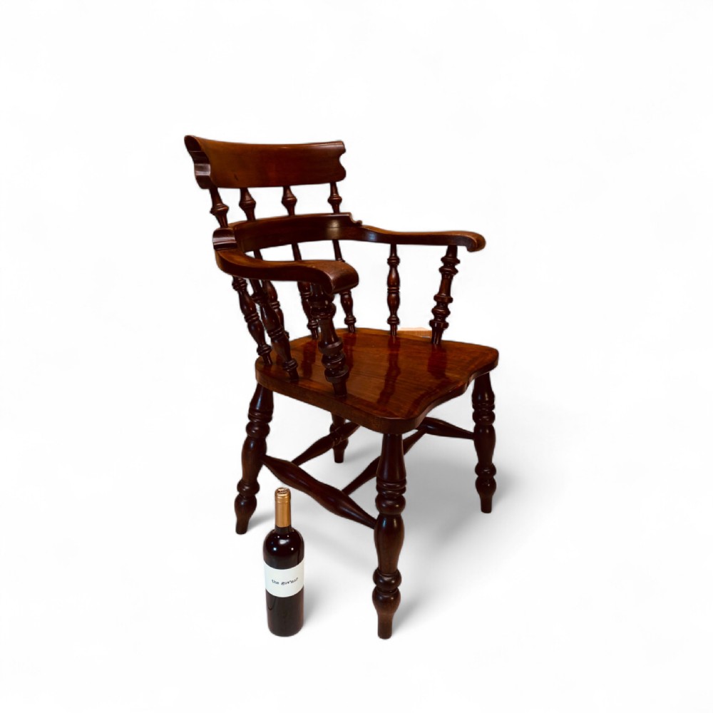 A set of sixteen matching comb back wooden Windsor armchairs made from brown ash and alder wood featuring turned spindles and shaped crest rails. View II