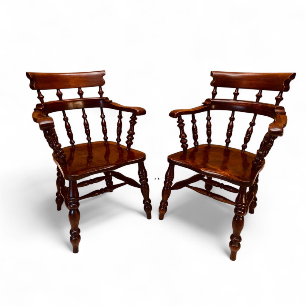 A set of sixteen matching comb back wooden Windsor armchairs made from brown ash and alder wood featuring turned spindles and shaped crest rails. View IV