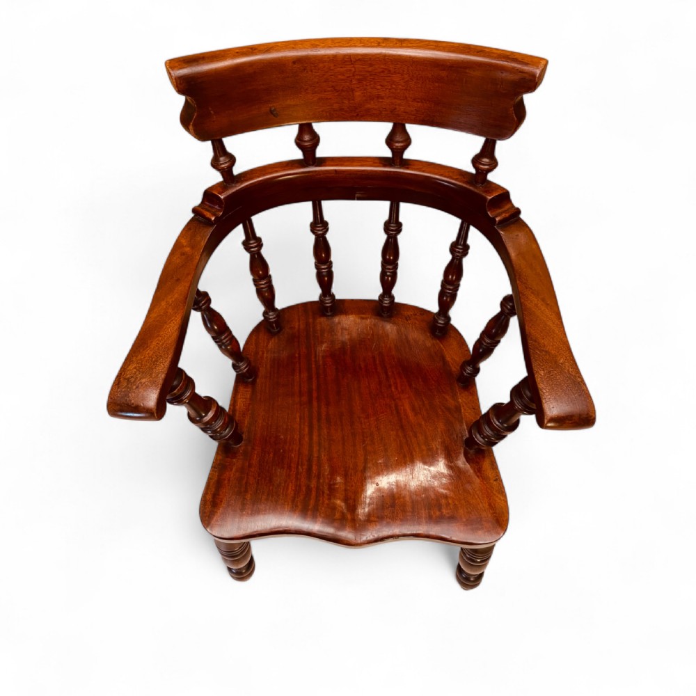 A set of sixteen matching comb back wooden Windsor armchairs made from brown ash and alder wood featuring turned spindles and shaped crest rails. View VI