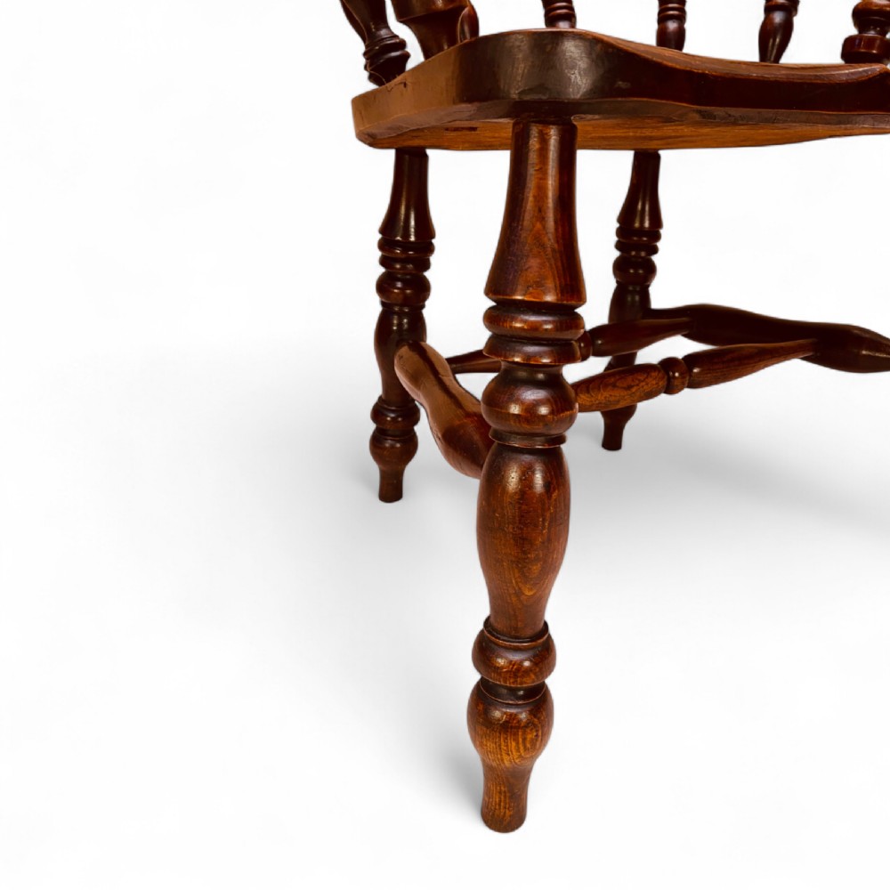 A set of sixteen matching comb back wooden Windsor armchairs made from brown ash and alder wood featuring turned spindles and shaped crest rails. View VIII