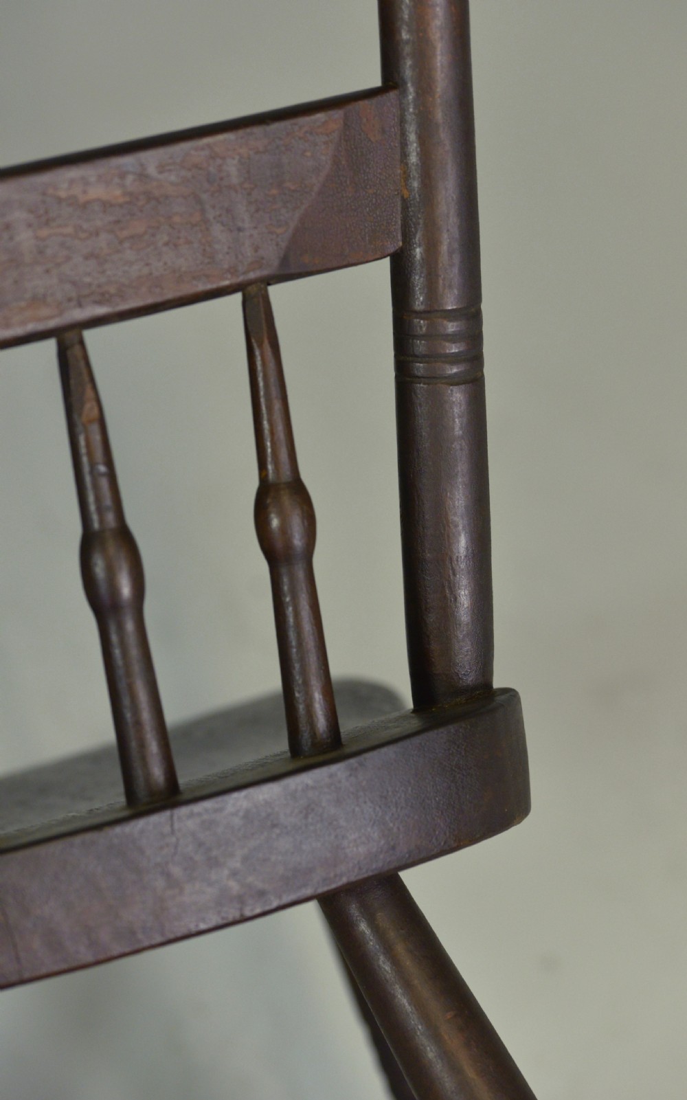 A pair of dark brown 19th-century American slat back wooden kitchen chairs featuring turned legs and back spindles. View III