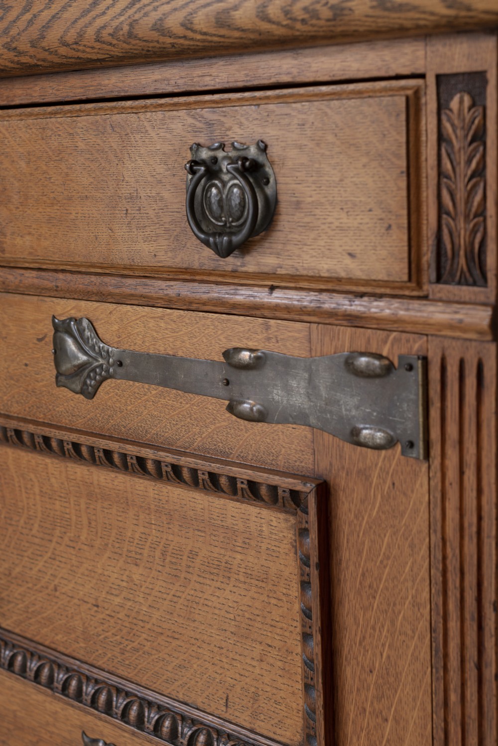 An antique Art Nouveau oak dresser featuring a mirrored upper tier with carved accents and a lower cabinet base with iron hardware. View IX