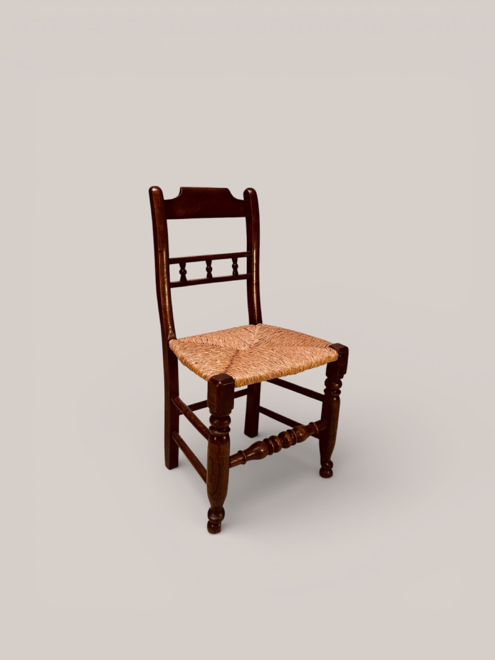 A set of dark ash and alder wood dining chairs featuring hand-woven rush seats, turned front legs, and decorative back spindles. View II